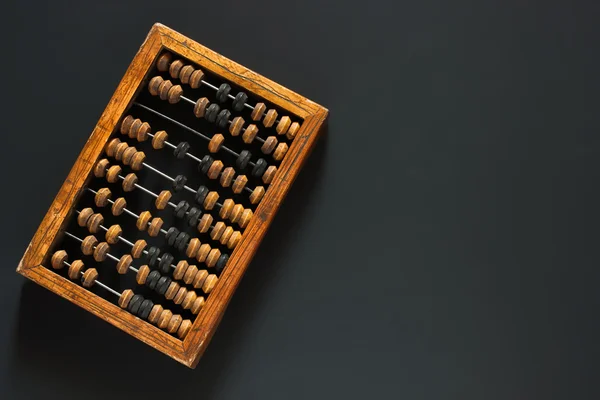Alte zerkratzte Vintage-Dezimalabakus aus Holz auf einem schwarzen Schreibtisch aus Kreidetafel mit Leerzeichen zur Beschriftung des Hintergrundes. Ansicht von oben. flache Lage. — Stockfoto