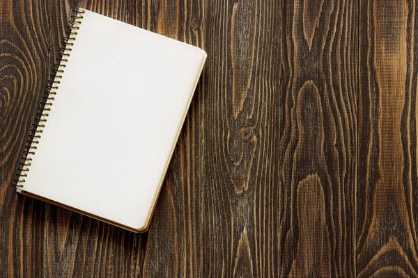Un simple cahier blanc vide avec un blanc pour dessiner ou écrire se trouve sur un bureau à partir d'une planche de bois. Vue de dessus. Maquette-toi. Pose plate — Photo