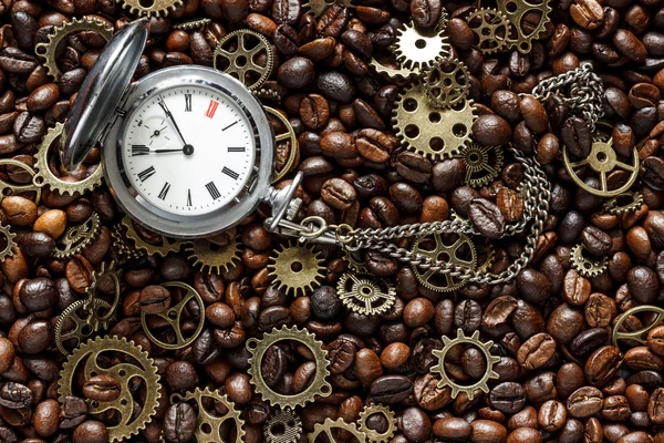 mock up for background in steampunk style. Roasted coffee beans mixed with brass gears and old pocket watch. Grunge style toned. Top view.