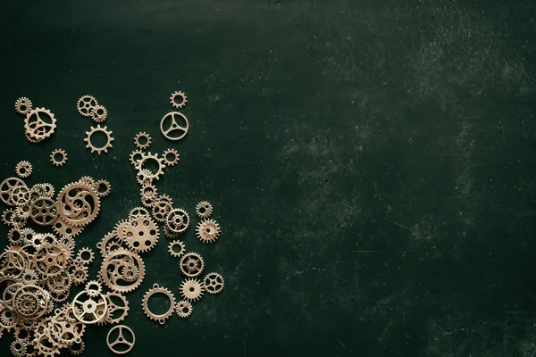 Naturwissenschaftliche Ausbildung oder mechanischer Hintergrund. alte Oldtimer-Zahnräder auf grüner Kreidetafel mit Rohling für die Textbeschriftung. von oben. Flatlay. Attrappe. Grunge-Stil abgemildert — Stockfoto