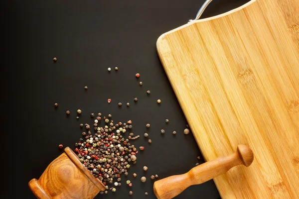 Mat bakgrund. Trämortel med olika kryddor och Tom skärbräda med blankutrymme för mock upp på svart Chalkboard. Topview. Mockup. Flatlay. — Stockfoto