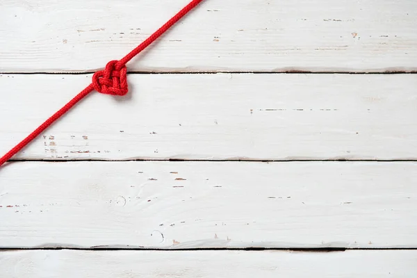 白い木製の背景に心の形で赤いロープ 平置きだ ベストバレンタインギフトカードのためのモックアップ — ストック写真