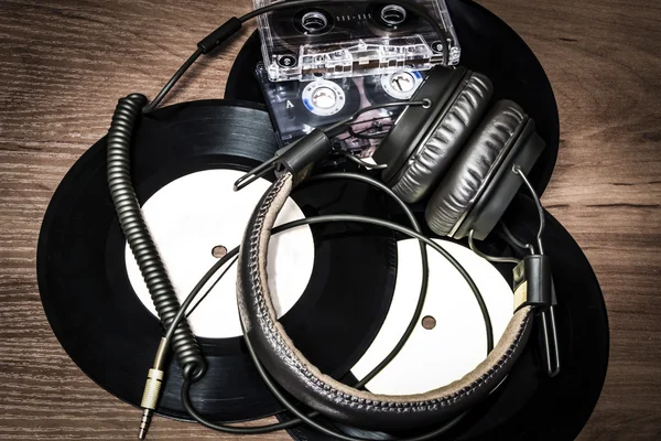 Tres discos, cassette de audio y auriculares yacen sobre una mesa de madera — Foto de Stock