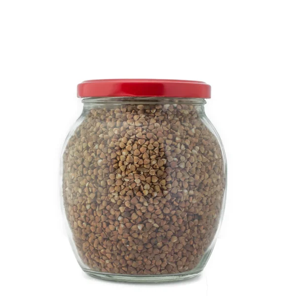 Glass jar with buckwheat closed red cap isolated — Stock Photo, Image