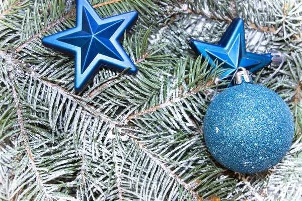 Verschiedene Dekorationen für Weihnachten und Neujahr, glänzendes Spielzeug, Sterne liegen auf Tannenzweigen. Ansicht von oben — Stockfoto