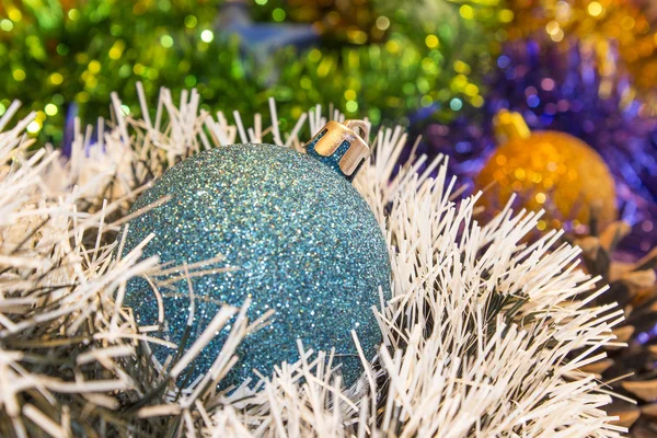 Hintergrund für Neujahrs- und Weihnachtskarten. Festlich leuchtende Regenbogendekorationen für Weihnachtsbäume oder Tannenbäume. Blaues Spielzeug im Fokus — Stockfoto