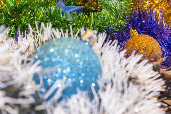 Hintergrund für Neujahrs- und Weihnachtskarten. Festlich leuchtende Regenbogendekorationen für Weihnachtsbäume oder Tannenbäume. Fokus auf gelbes Spielzeug — Stockfoto