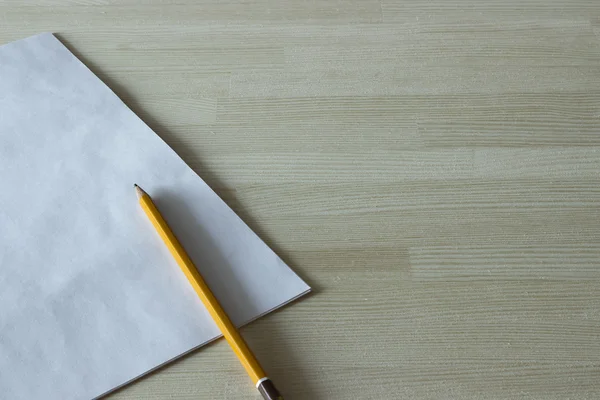 Feuille blanche vierge et crayon couché sur une table en bois . — Photo