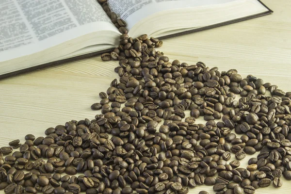Book and coffee beans on a wooden table — Stock Photo, Image
