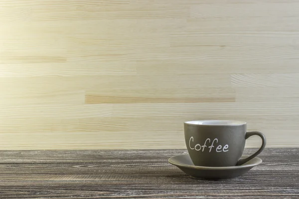 Tazza di caffè in piedi su un angolo di tavolo di legno — Foto Stock