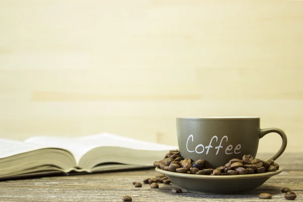 책의 배경에 콩 커피 한잔. 컵의 가장자리에 초점 — 스톡 사진