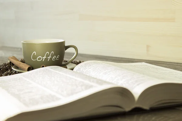 책의 배경에 콩 커피 한잔. 컵에 초점 — 스톡 사진