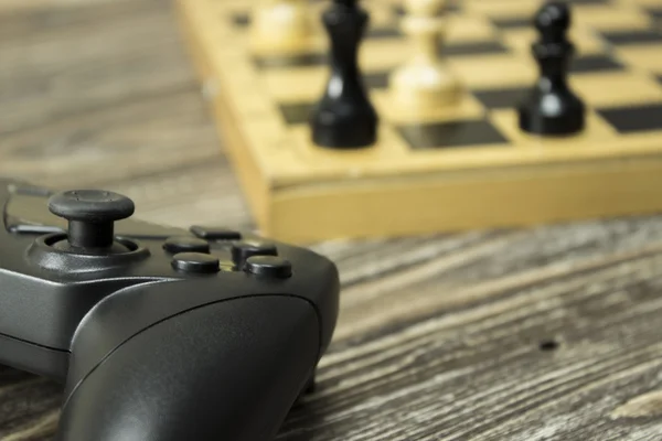 Gamepad και το σκάκι του σκάφους με στοιχεία για το ξύλινο υπόβαθρο. Επικεντρωθεί στην gamepad — Φωτογραφία Αρχείου