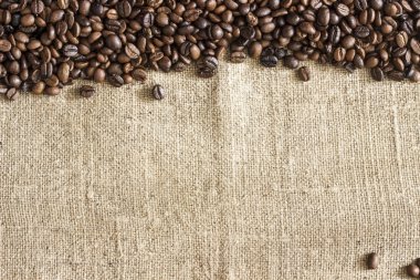 Çuval bezi tuval üzerine kavrulmuş kahve çekirdeklerini karesi dağınık