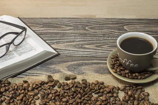 흩어져있는 커피 원두와 커피와 안경과 오픈도 서의 컵은 삼 베 조각에 스탠드. — 스톡 사진