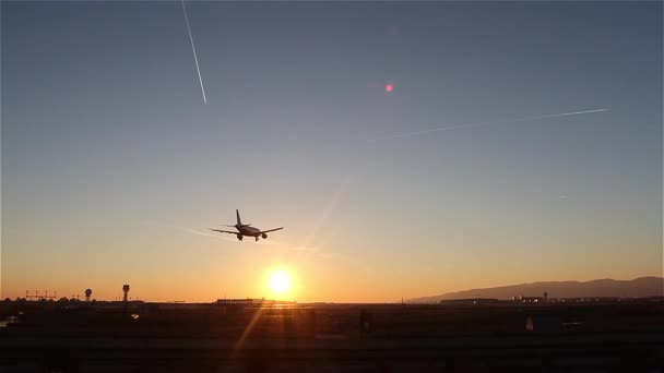 Avión aterrizando en el aeropuerto de Barcelona al atardecer — Vídeos de Stock