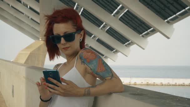 Graded shot of a tattooed woman using a smart phone 4K UHD shot
