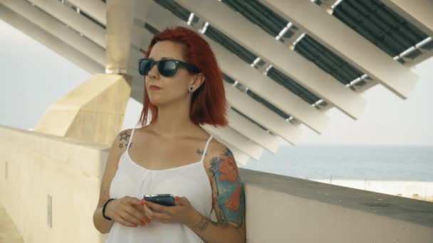 Tetovált nő használ a szúró telefon, egy nagy napelem 4k Uhd lövés