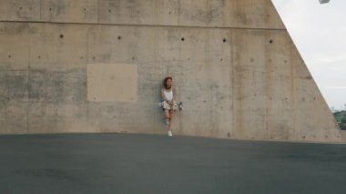 Dövmeli kırmızı baş kadın onun kaykay beton duvarla duruyor