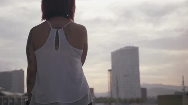 Женщина смотрит на город и здания в замедленной съемке — стоковое видео