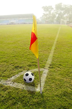 bir futbol sahası üzerinde topu ile köşe bayrak