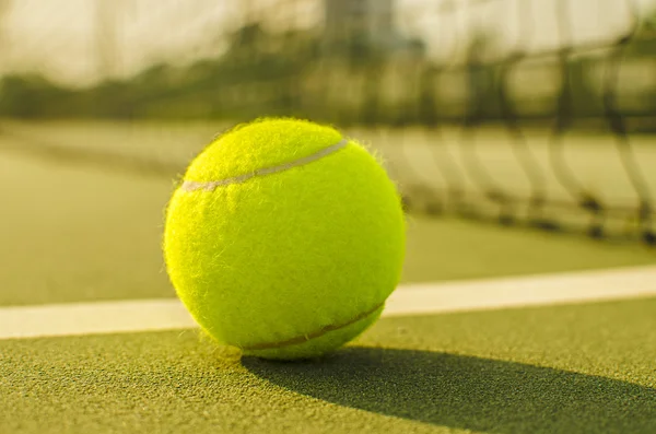 Pelota de tenis en la cancha con la red en el fondo —  Fotos de Stock