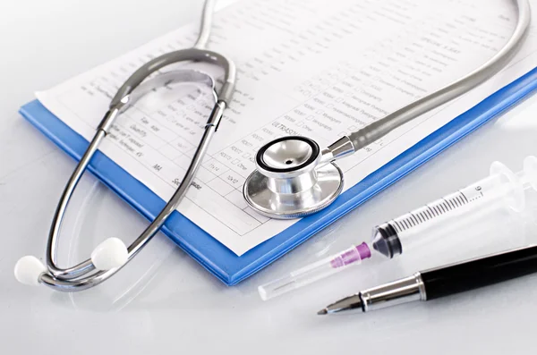 Medical history on clipboard with stethoscope on light backgroun — Stock Photo, Image