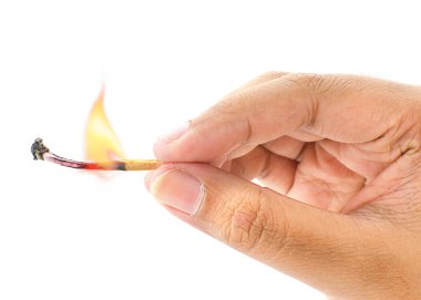 Ateş bir kibrit çöpü beyaz bir arka plan üzerinde tutan el