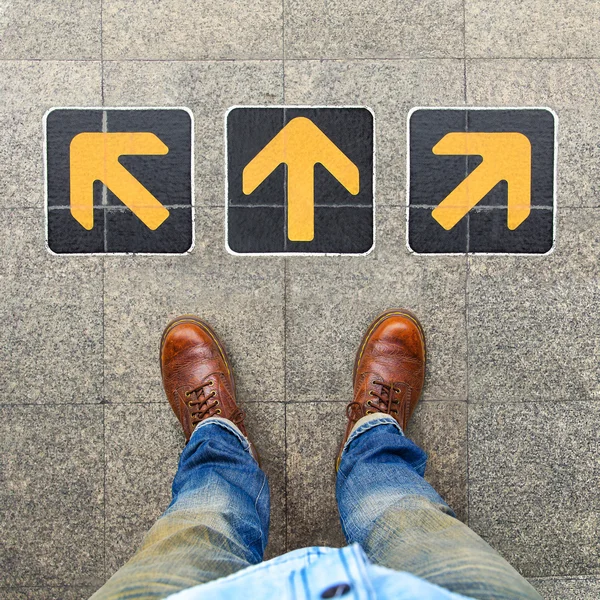 Vista superior del hombre de negocios de pie contra las direcciones de fondo — Foto de Stock