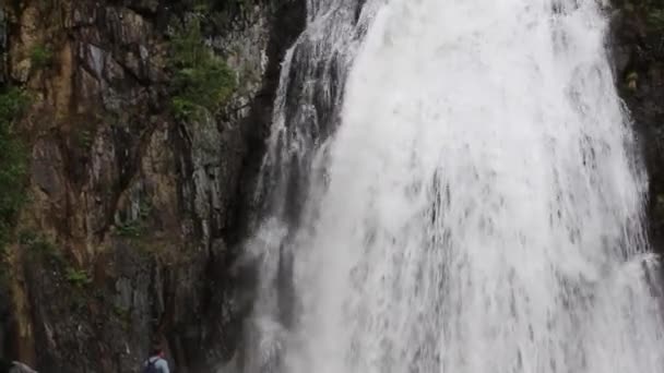 El hombre al pie de la cascada — Vídeos de Stock