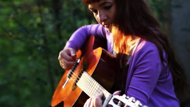 Hermosa chica pelirroja tocando la guitarra — Vídeos de Stock