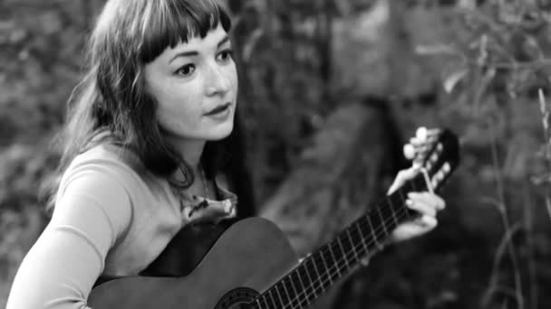 Beautiful girl playing the guitar. Monochrome — Stock Video