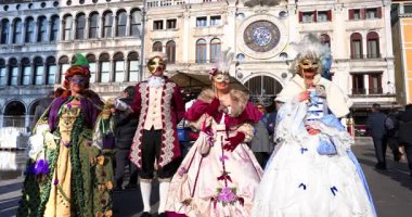 2026 Karnavalı - Maskeli insanlar 2002-01-2026 'da Venedik' teki St. Mark Meydanı 'nda bir videocuya poz verdiler