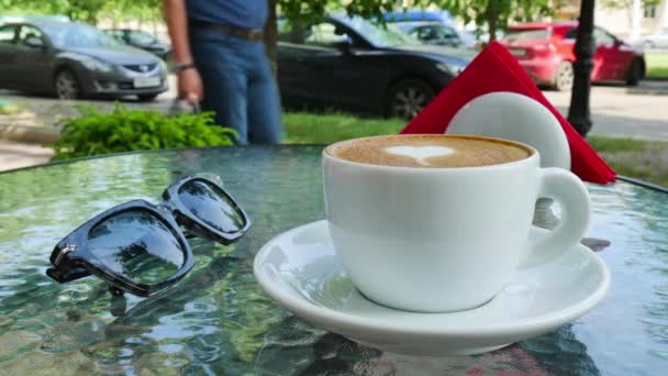 Uma xícara de café com amor. Os óculos estão nas proximidades do copo Videoclipe