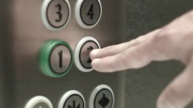 Adam bir düğme ikinci katta bir asansör içinde presler