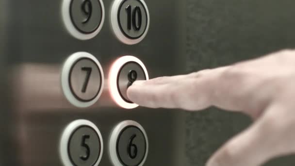 Man op een knop drukt de achtste verdieping in een lift — Stockvideo