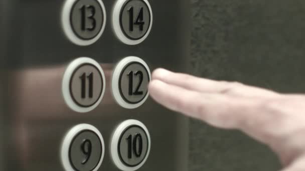 Man op een knop drukt de twaalfde verdieping in een lift — Stockvideo