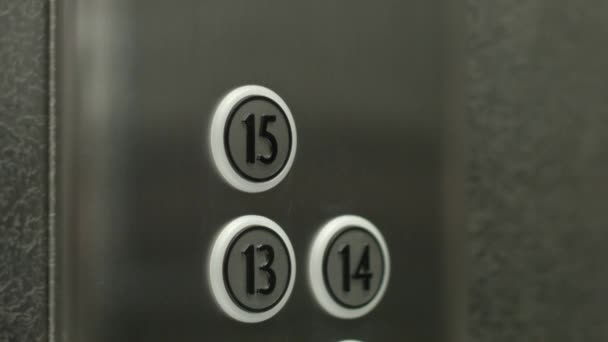 Man op een knop drukt de vijftiende verdieping in een lift — Stockvideo
