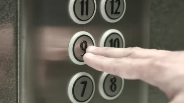 Мужчина нажимает кнопку на девятом этаже лифта — стоковое видео
