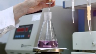 inceleyerek bilim adamı örnek ve sıvı şişesi içinde karıştırın