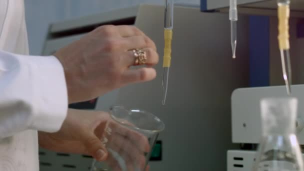 Resercher colher amostra de líquido em frasco — Vídeo de Stock