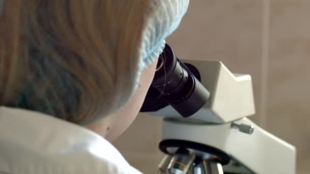 Forskere ser gjennom mikroskop – stockvideo