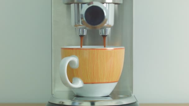 Hacer café usando la máquina de café en una taza de naranja — Vídeos de Stock