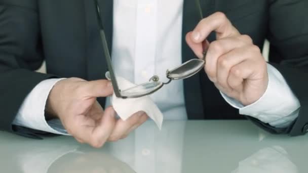 El hombre toma sus gafas y las limpia. — Vídeos de Stock