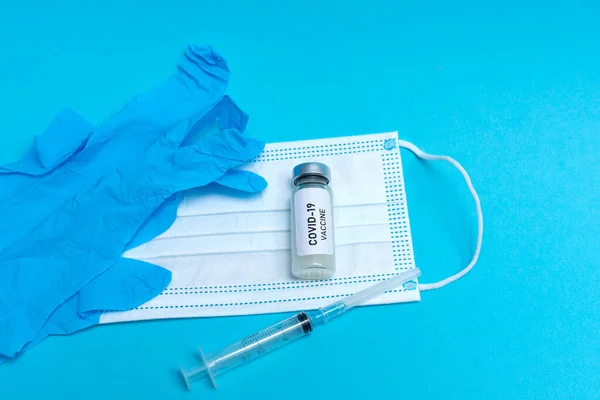 Flat lay top view niebieskie rękawice medyczne z maską i szczepionką covid-19 — Zdjęcie stockowe