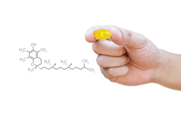 E vitamini hap kırpma yoluyla tutan el