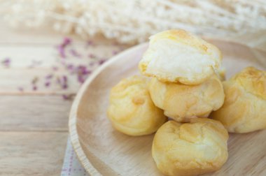 Vanilya krem eklerleri ahşap masa üzerinde