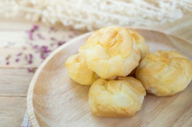 Vanilya krem eklerleri ahşap masa üzerinde