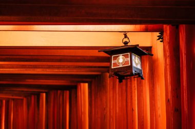 Japonya 'nın Kyoto kentindeki Fushimi Inari Taisha Tapınağı' nın turuncu kırmızı torii kapılarındaki güzel fener süslemeleri.