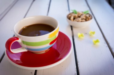 Beyaz ahşap masa üzerinde kırmızı kahve fincanı